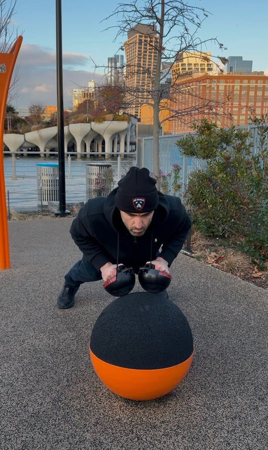 The Black Made in the USA beanie is warm and great for outdoor calisthenics workouts. Elevated close grip push-ups with the AB SHIELD BOSS. New York city's Little Island park in the background.